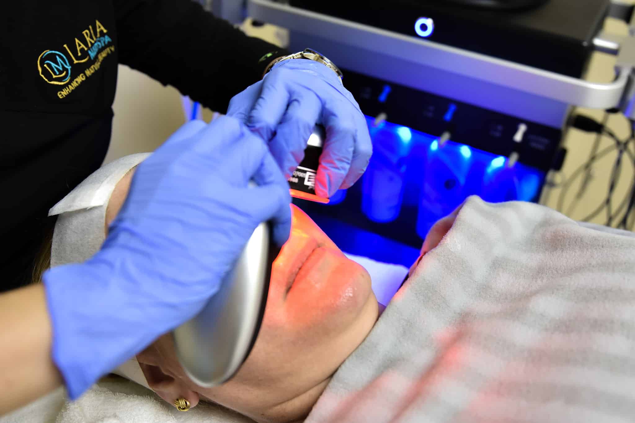 patient lying down receiving laser facial treatment